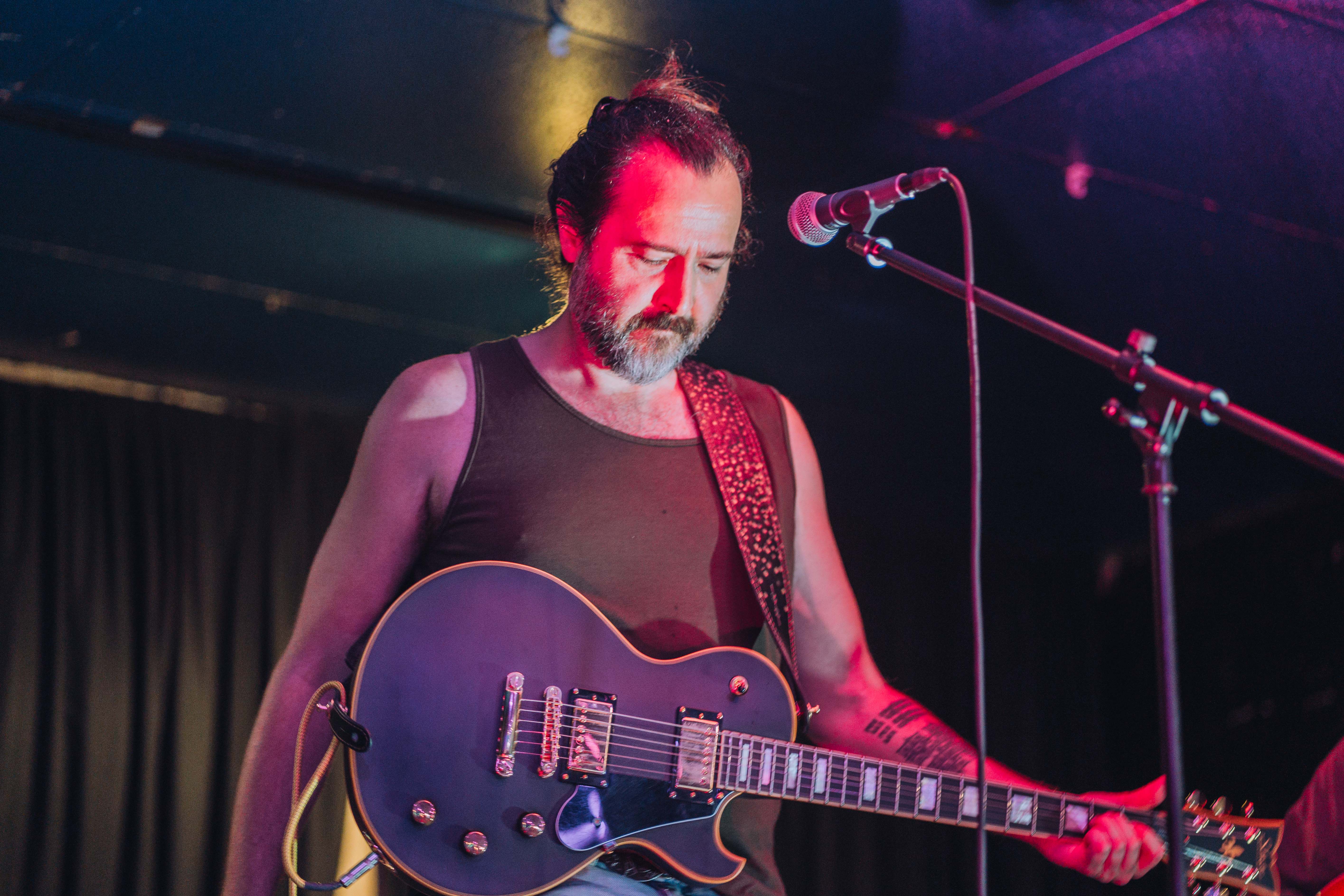 David holding a chord on electric guitar while looking down